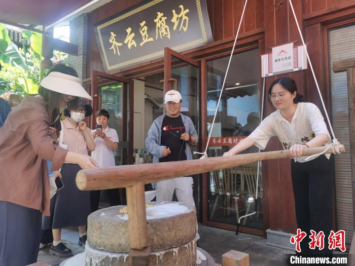 游客体验豆腐制作技艺。　张强 摄