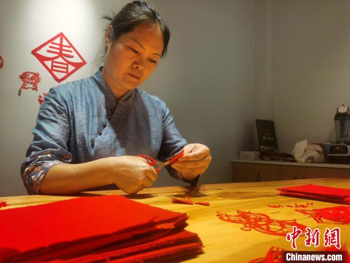 安徽省非遗徽州剪纸传承人吴笑梅正在创作。　张强 摄